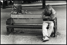 400891 Afbeelding van een (vermoedelijk) dakloze jongeman op een bankje op het Janskerkhof te Utrecht.